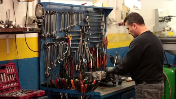 Mecánico de automóviles reparando una parte de un motor de coche — Vídeos de Stock