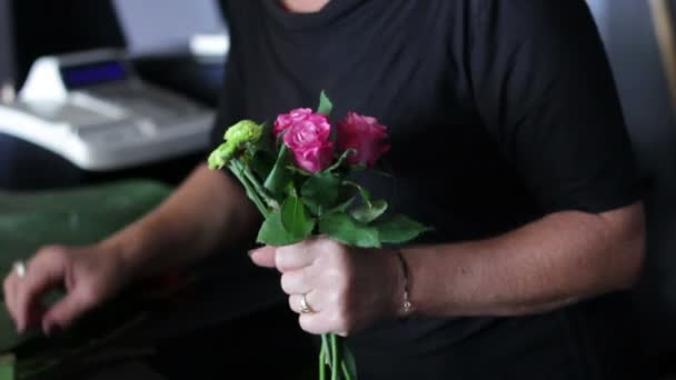 Florist som förbereder en bukett av rosa blommor — Stockvideo