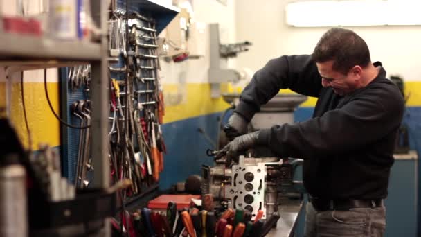 Auto mechanic repairing a part of a car engine — Stock Video