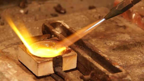 orfèvre fondre une pièce d'argent 