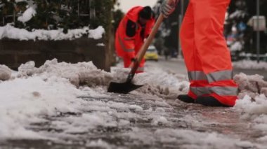 Kaldırım temizlemek için kar kürekle erkekler