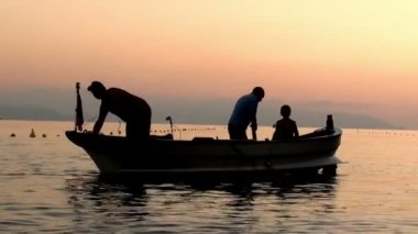 balıkçılar balıkçılık için günbatımı bırakarak, teknede silüeti