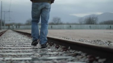 Tren yolda yürüyen adam
