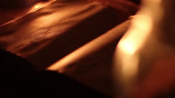 Old book in candlelight — Stock Video