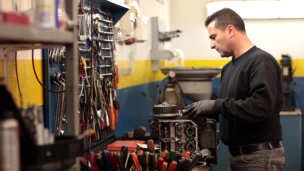 Auto mechanic repairing a part of a car engine — Stock Video