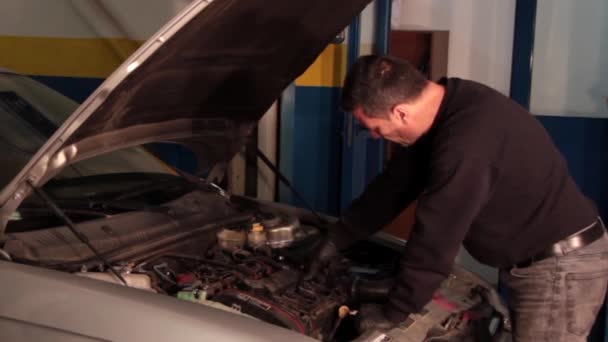 Mécanicien automobile réparant une partie d'un moteur de voiture 