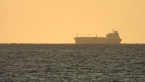 Coucher de soleil doré et silhouette du cargo — Video