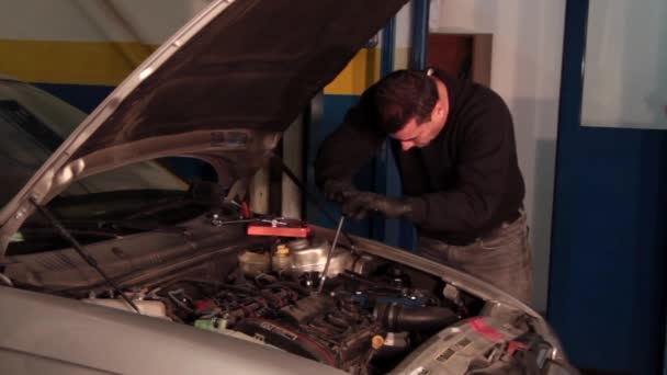 Mecánico de automóviles reparando una parte de un motor de coche — Vídeos de Stock