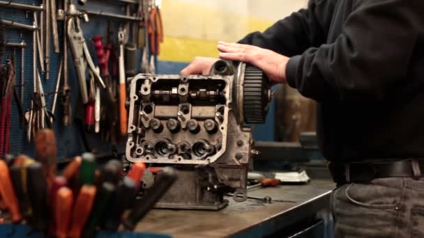 Mecánico de automóviles reparando una parte de un motor de coche — Vídeo de stock