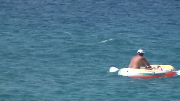 Bather on the raft paddling in the sea — Stock Video