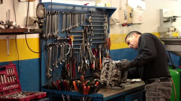 Mecánico de automóviles reparando una parte de un motor de coche — Vídeo de stock