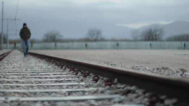 Hombre caminando en las vías del tren — Vídeo de stock