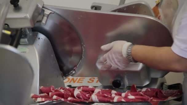 Detalj av slaktare skivning färsk skinka med maskinen — Stockvideo