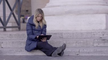 Tablet kullanan genç bir kadın.