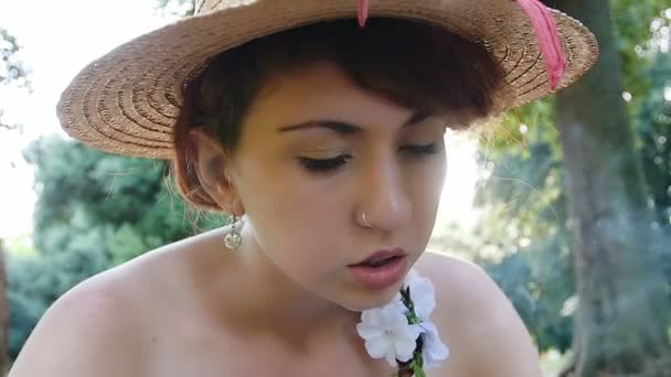 Όμορφη νεαρή γυναίκα που καπνίζει στο πάρκο — Αρχείο Βίντεο