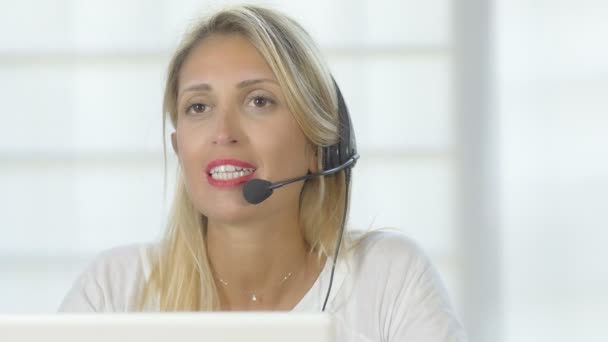 Mujer que trabaja con auriculares en un centro de llamadas — Vídeo de stock
