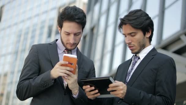 Pessoas de negócios usando smartphone e tablet computador perto do escritório: trabalho em equipe — Vídeo de Stock