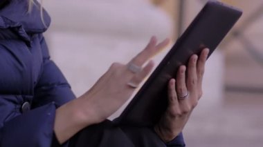 Tablet kullanan genç bir kadın.