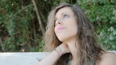 bahçede oturan düşünceli genç kadın