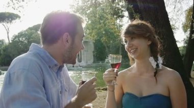 Genç çift kırmızı şarap içiyor.