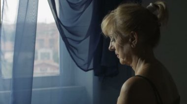 üzgün, üzgün ve endişeli kadın pencereden dışarı bakıyor: sorunlar, üzüntü