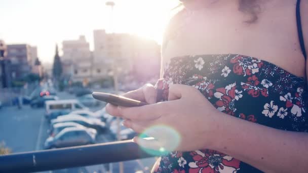 Cute girl using smartphone in summertime: typing text message on mobile phone — Stock Video