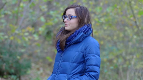 Sonriente joven en el parque en un día de invierno frío y ventoso — Vídeos de Stock