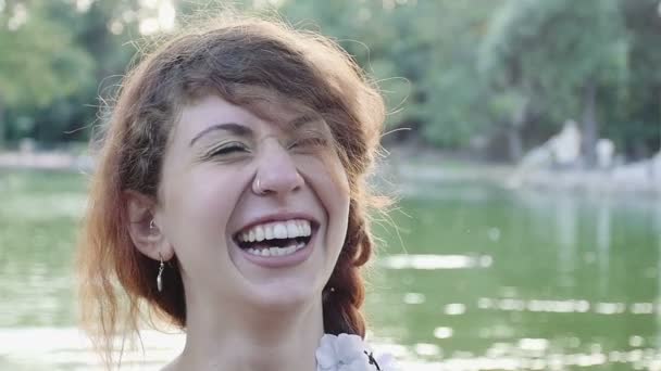 Feliz joven sonriendo en el parque: al aire libre, divirtiéndose, riendo — Vídeos de Stock