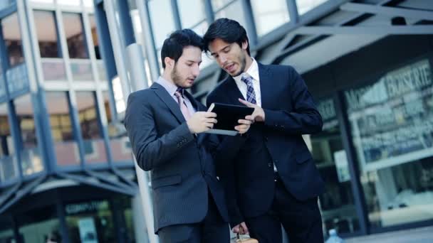 Biznesmeni, przechodząc w pracy i przy użyciu tabletu i smartfona — Wideo stockowe