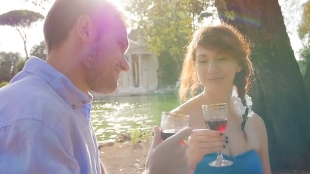 Jovens amantes bebendo vinho tinto — Vídeo de Stock