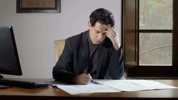 Absorbido hombre de negocios estudia su presentación de negocios, playng con una pluma — Vídeos de Stock