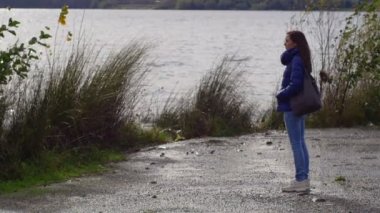 bir soğuk kış günü yalnız ve üzgün bir göl yakınında duran genç kadın: düşünceli