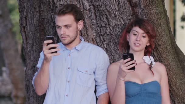 Женщина и мужчина играют с мобильными телефонами — стоковое видео