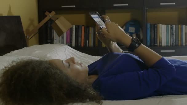Молодая кудрявая женщина путешествует по интернету со смартфоном: мобильный телефон, 4k — стоковое видео