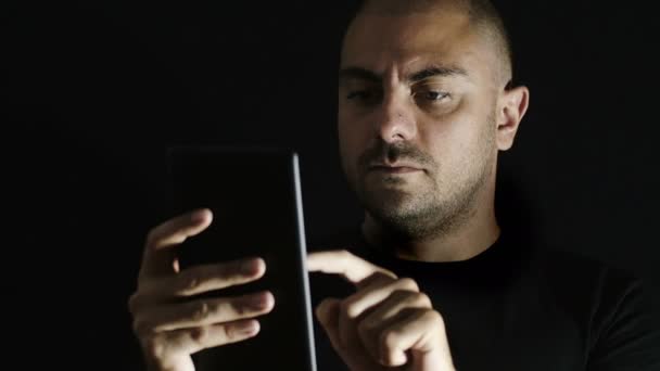 Tablet veya smartphone karanlıkta kullanan adam: dokunmatik ekran, parmak, Internet — Stok video