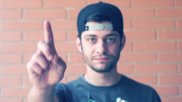 Young man with cap looking at camera and says no with hand. Slowmotion — Stock Video