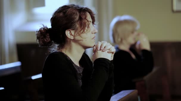 Oración intensa de dos mujeres en una iglesia: religión, fe, devoción, católicos — Vídeos de Stock