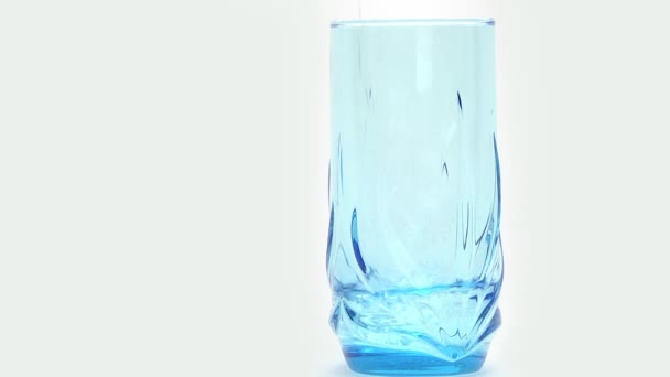 Pouring water into a blue glass — Stock Video