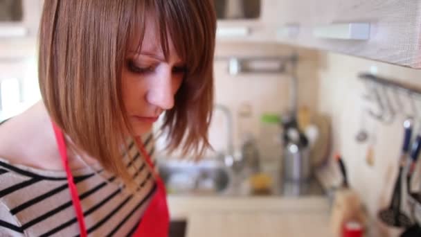 Jonge vrouw is koken in de keuken — Stockvideo