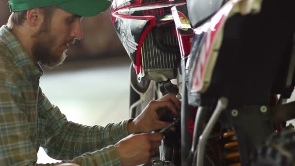 Sportif masculin réparant sa moto enduro — Video