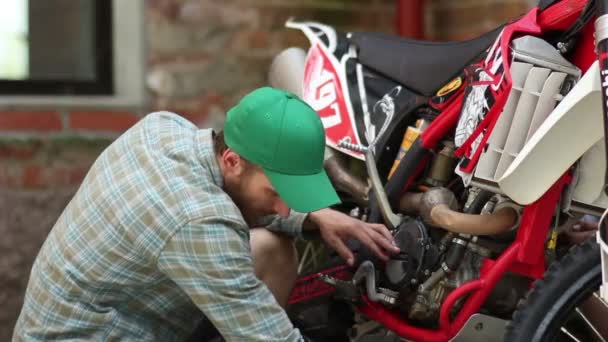 Deportista masculino reparando su motocicleta enduro — Vídeo de stock