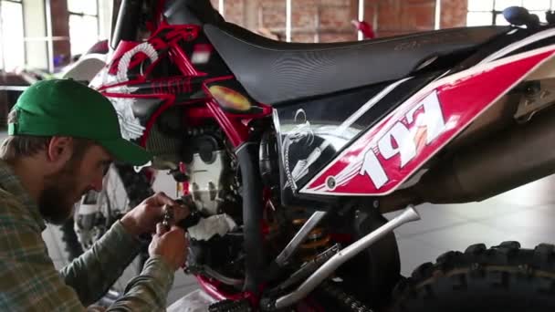 Male sportsman repairing his enduro motorcycle — Stock Video