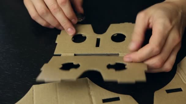 Girl assembling a Virtual Reality cardboard glasses — Stock Video