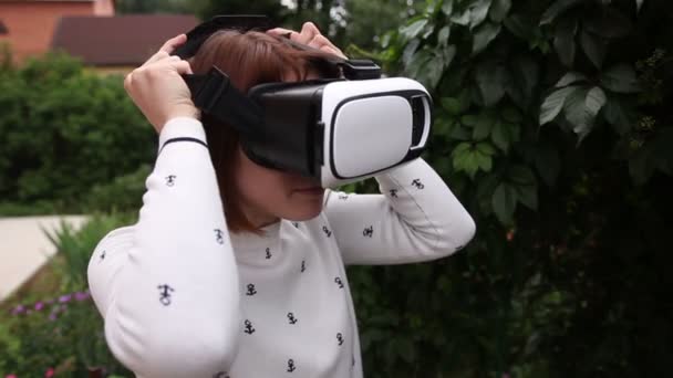 Молода руда жінка використовує VR-шолом для смартфонів. Доповнена реальність — стокове відео