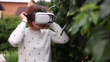 VR-kask için akıllı telefonlar kullanan genç Kızıl saçlı kadın. Artırılmış gerçeklik