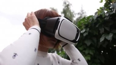VR-kask için akıllı telefonlar kullanan genç Kızıl saçlı kadın. Artırılmış gerçeklik