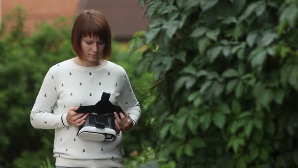 Junge rothaarige Frau mit vr-Helm für Smartphones. Erweiterte Realität — Stockvideo