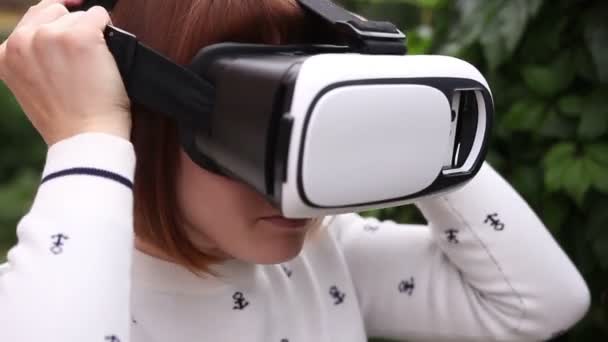 Vr 헬멧을 사용 하 여 스마트 폰에 대 한 젊은 빨강 머리 여자. 증강된 현실 — 비디오