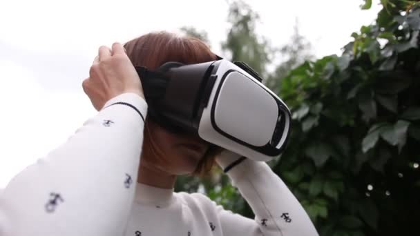 Jonge roodharige vrouw met behulp van Vr-helm voor slimme telefoons. Augmented reality — Stockvideo