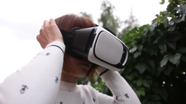 Mujer pelirroja joven usando casco VR para teléfonos inteligentes. Realidad aumentada — Vídeos de Stock